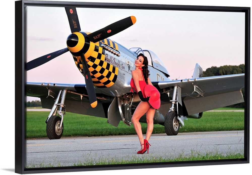Sexy 1940's style pin-up girl posing with a P-51 Mustang fighter plane.