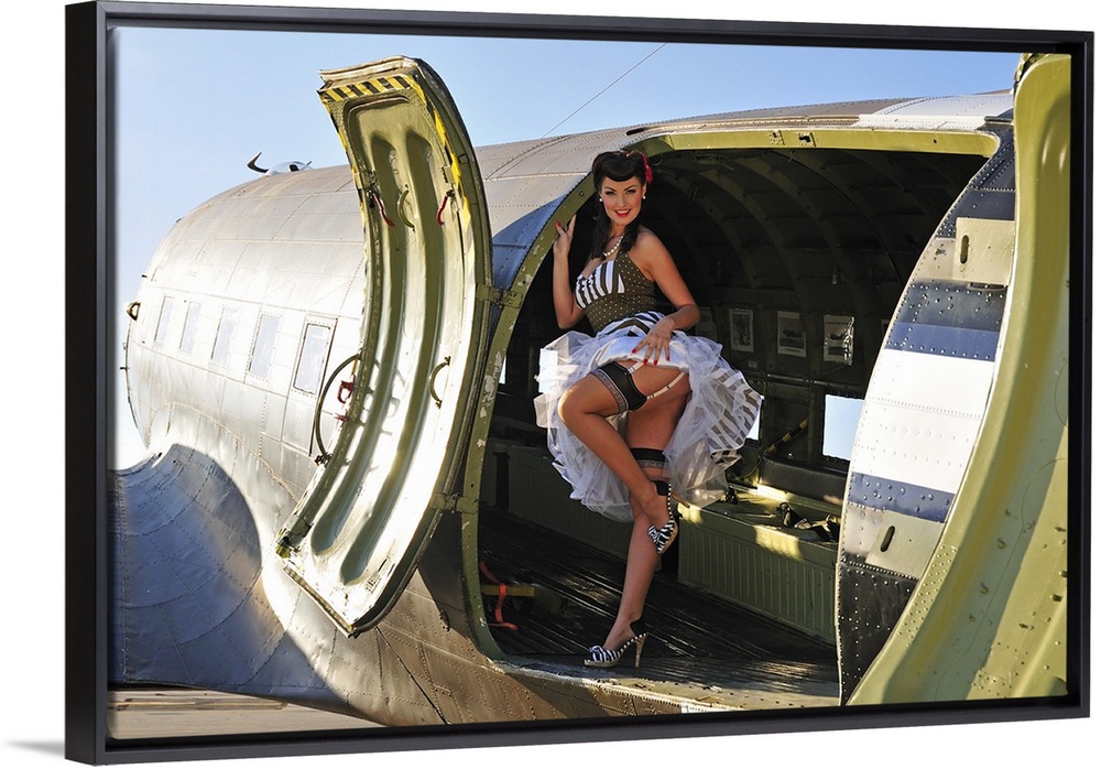 Sexy 1940's style pin-up girl with stockings, standing inside of a World War II C-47 Skytrain aircraft.