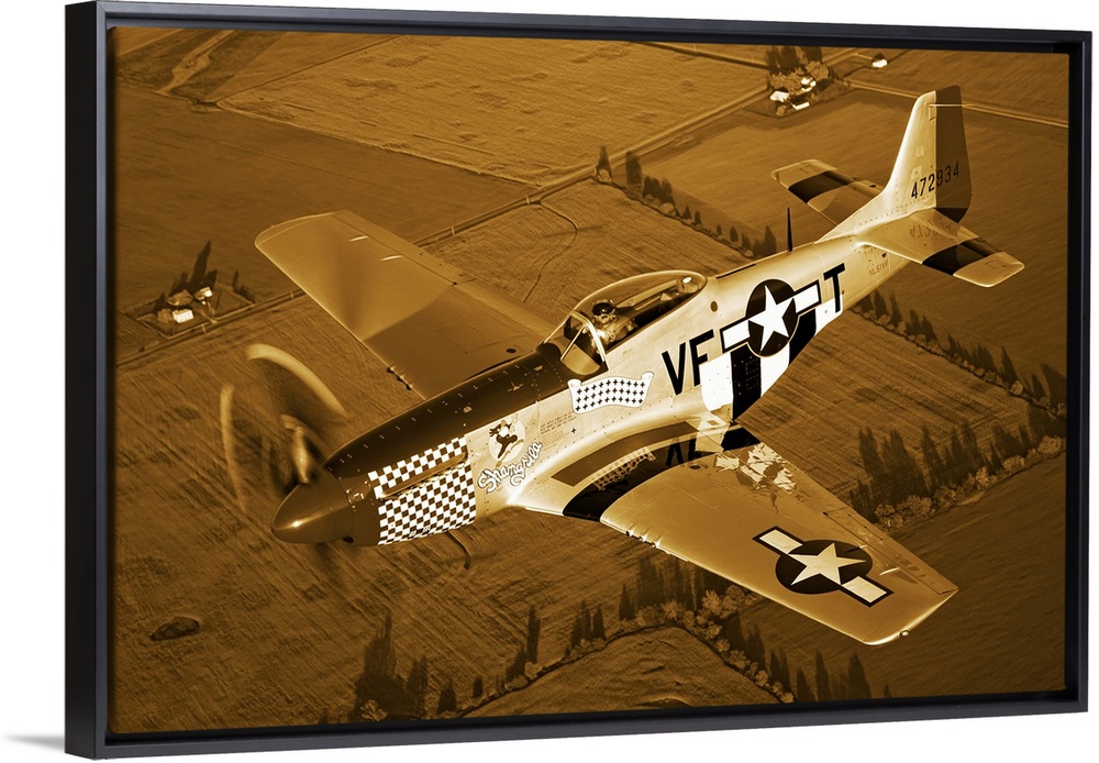 Big, horizontal photograph of a North American P-51D Mustang in flight near Columbus, Ohio, over farm fields.