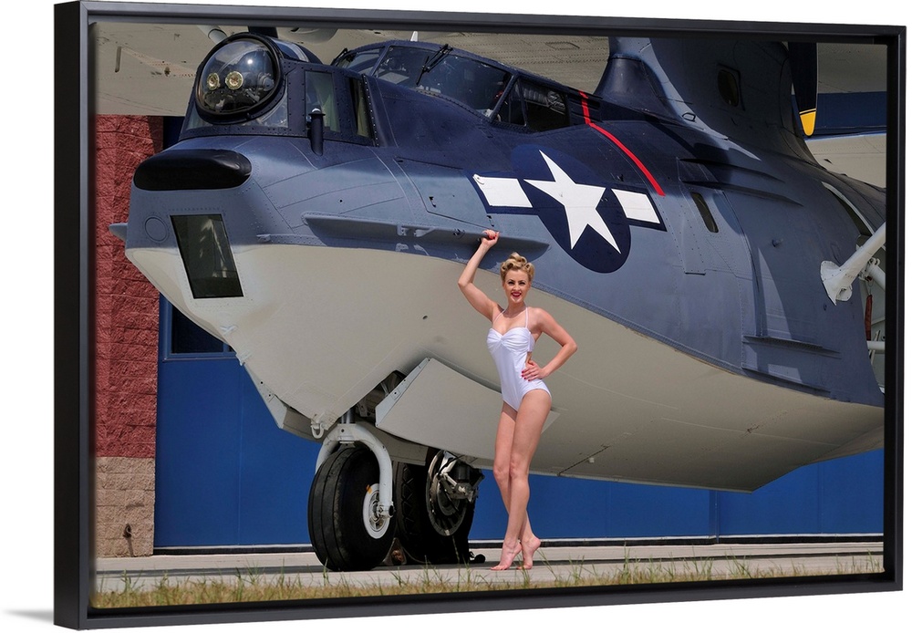 Retro pin-up girl posing with a World War II era PBY Catalina seaplane.