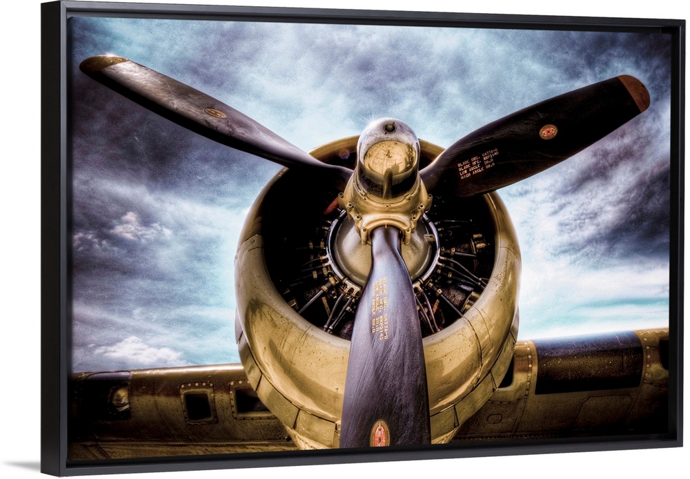 Front view photograph of vintage airplane with a dark cloudy sky in the background.