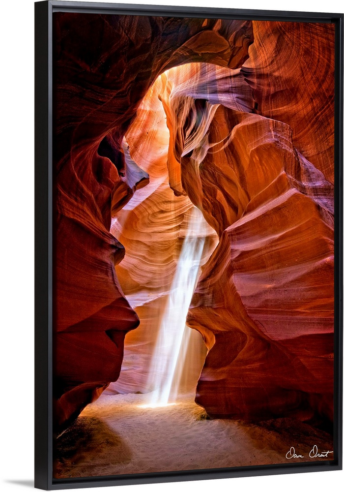Photograph of the sun shining through the canyon top onto the sand in Antelope Canyon.