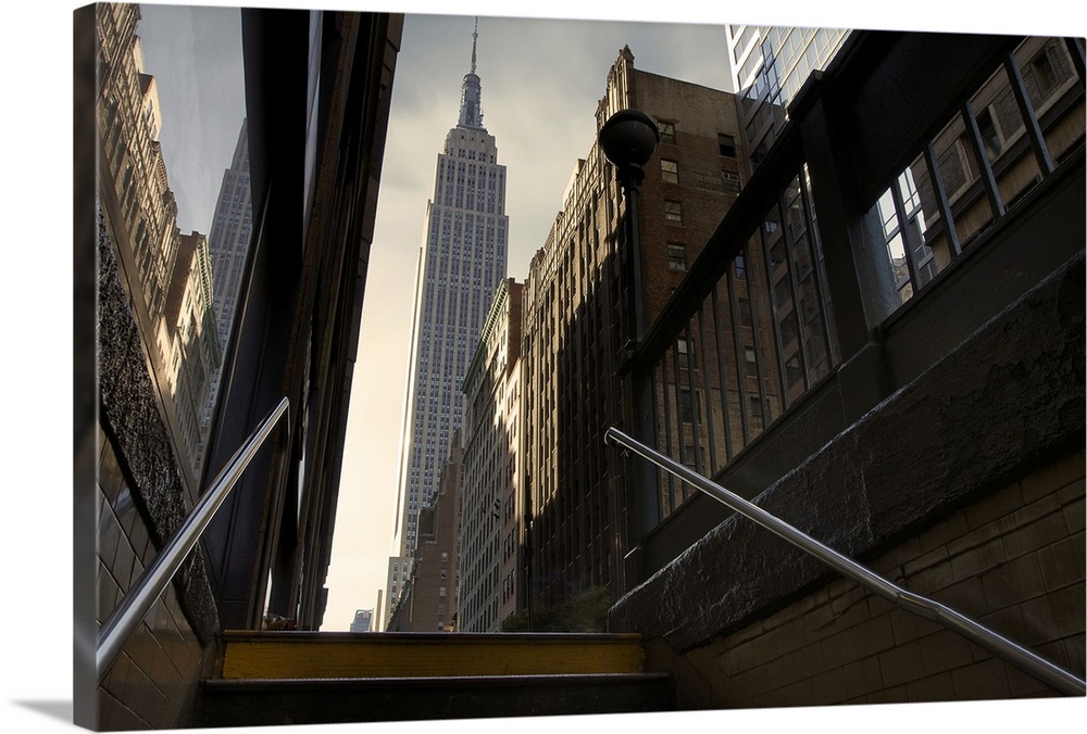 Photograph looking up towards the Empire State Building in NYC from the subway staircase.