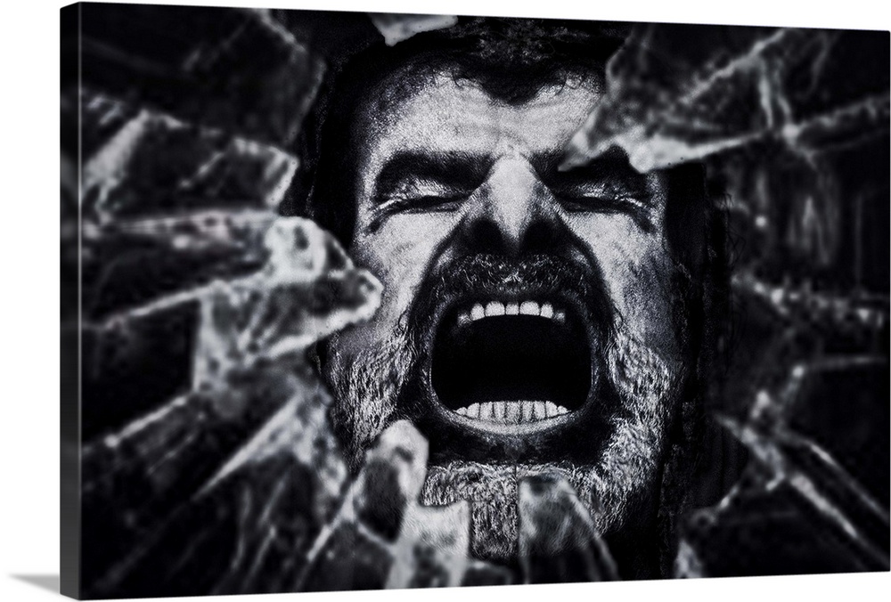 Conceptual photograph of a man face seen through a hole of shattered glass.