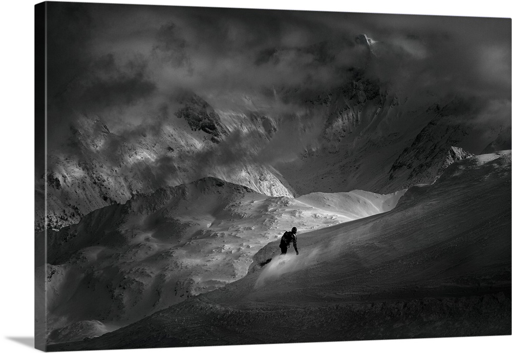 A snowboarder racing down a dark slope in the Alps.