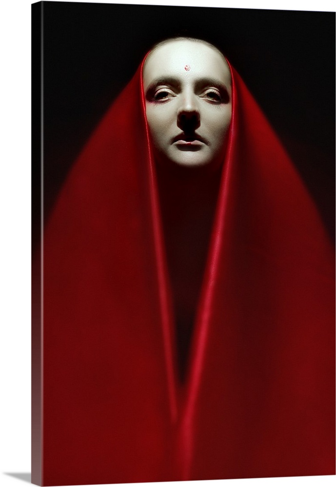 Portrait of a person wearing a long red veil over their head and around their body.