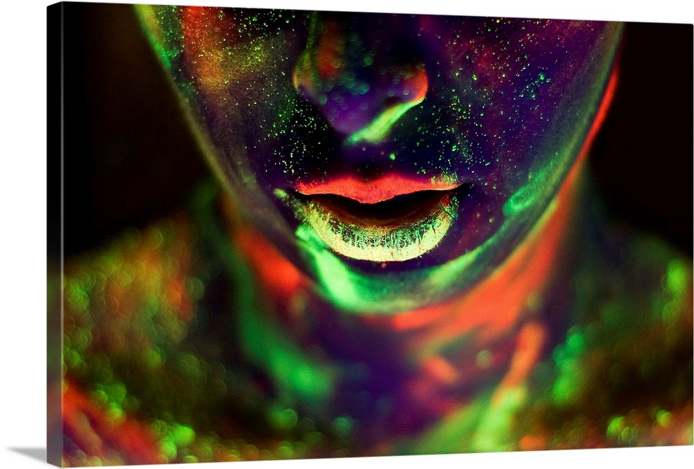 A woman's face and neck covered in glow-in-the-dark paint in neon colors.