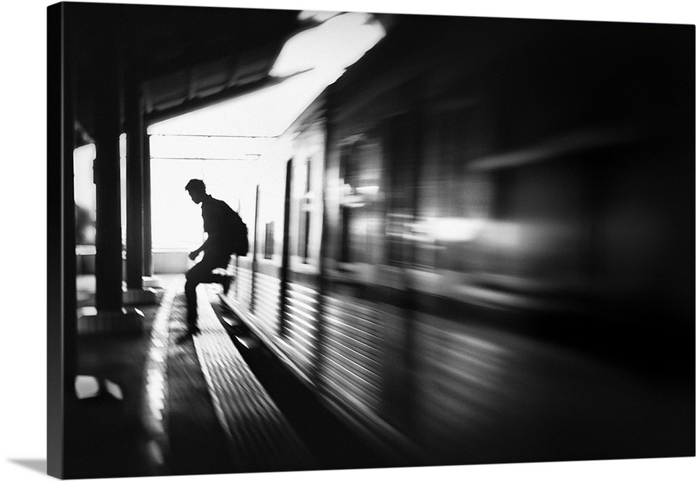 Blurred motion image of a man jumping out of a train at the station in Jakarta.