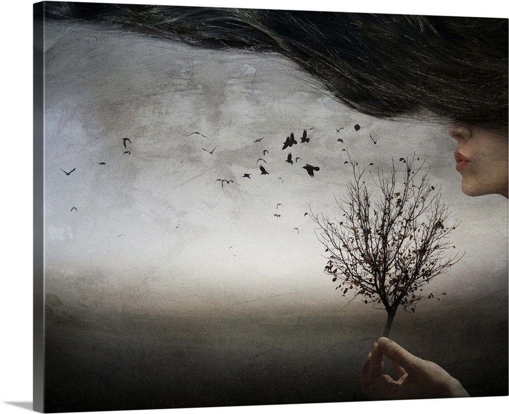 Conceptual image of a woman with long hair holding a tree and blowing through the branches.