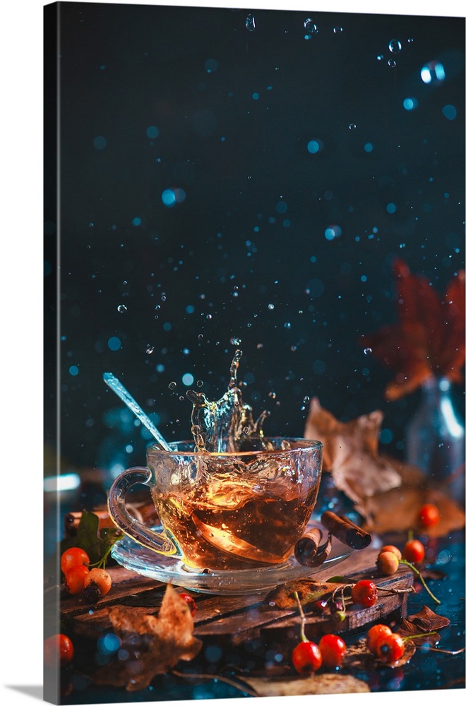 Action autumn still life with tea cup, wooden coaster, autumn leaves and berries, teaspoon and a frozen in motion splash o...