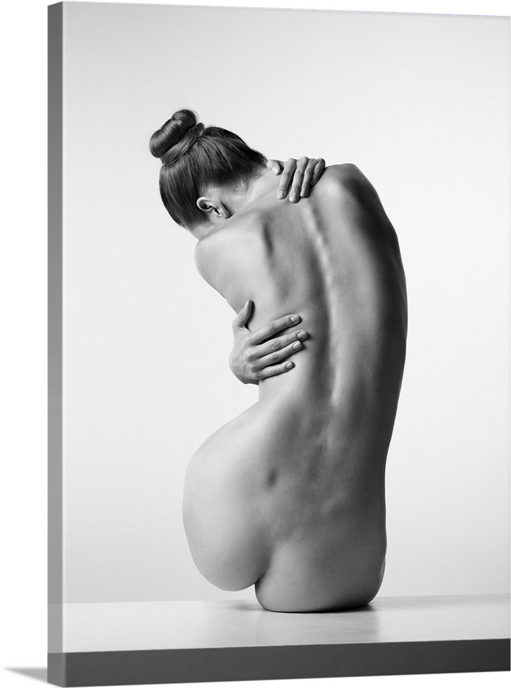 Black and white fine art photograph of a nude woman from behind creating movement with her body.