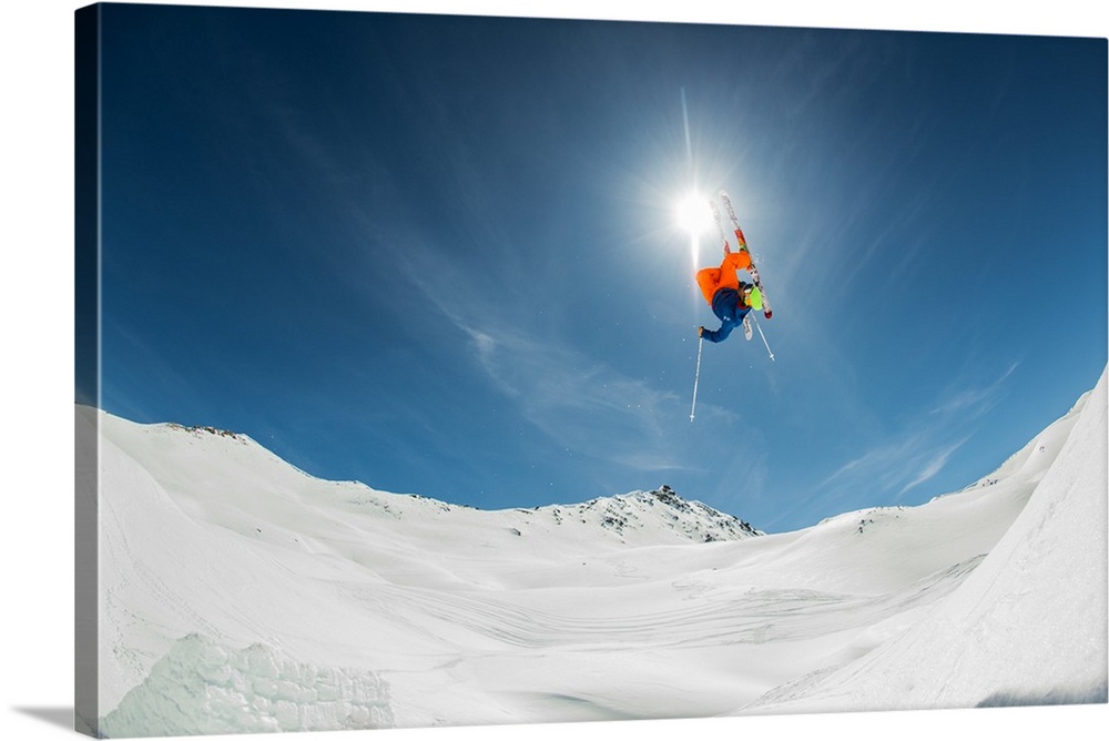 A skier flying through the air over a snowy landscape, Italy.