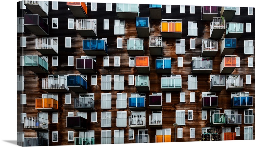 Balconies with colorful glass panels protruding from the side of an apartment building.