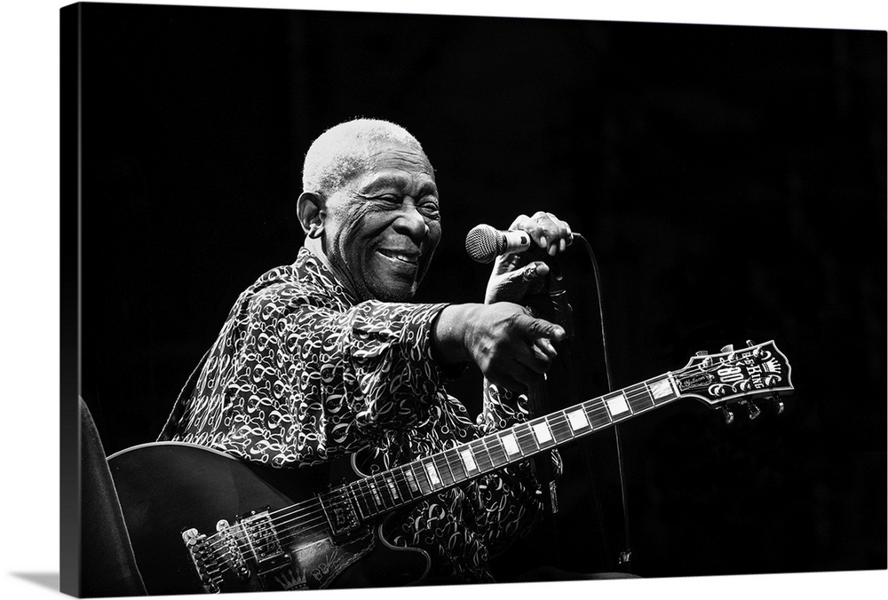 Portrait of a blues musician on stage pointing to a fan in the crowd.