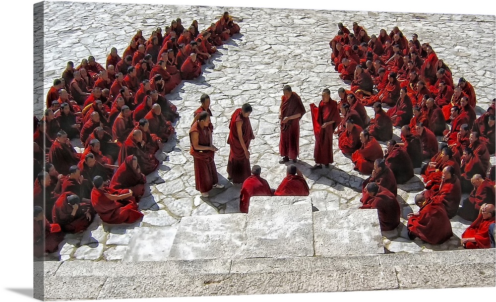 Buddhist monks in traditional red robes gathering on stone steps.