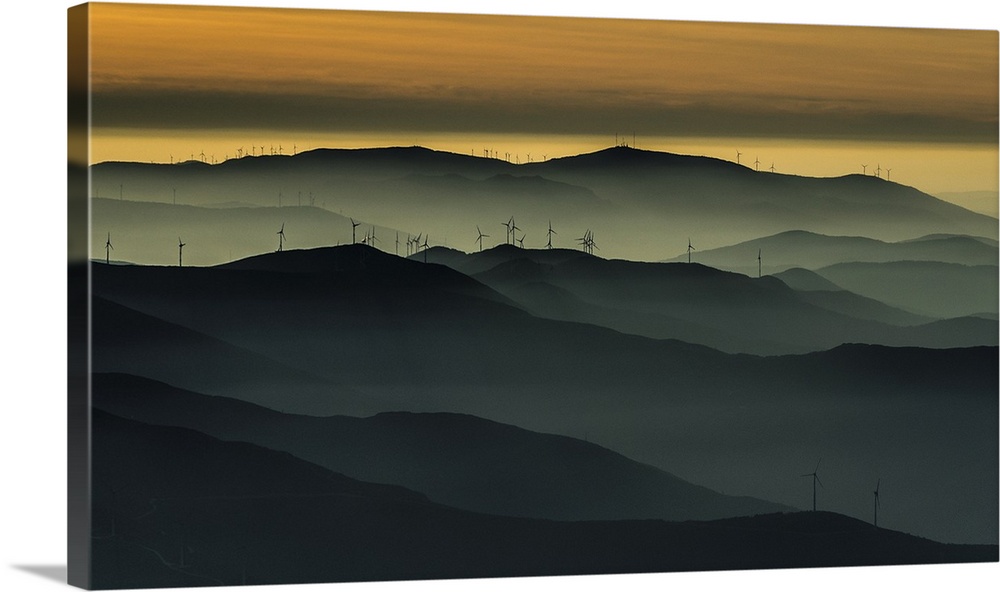 Heavy fog settling over a wind farm in Portugal at sunset, in the Acor and Lousa mountains.