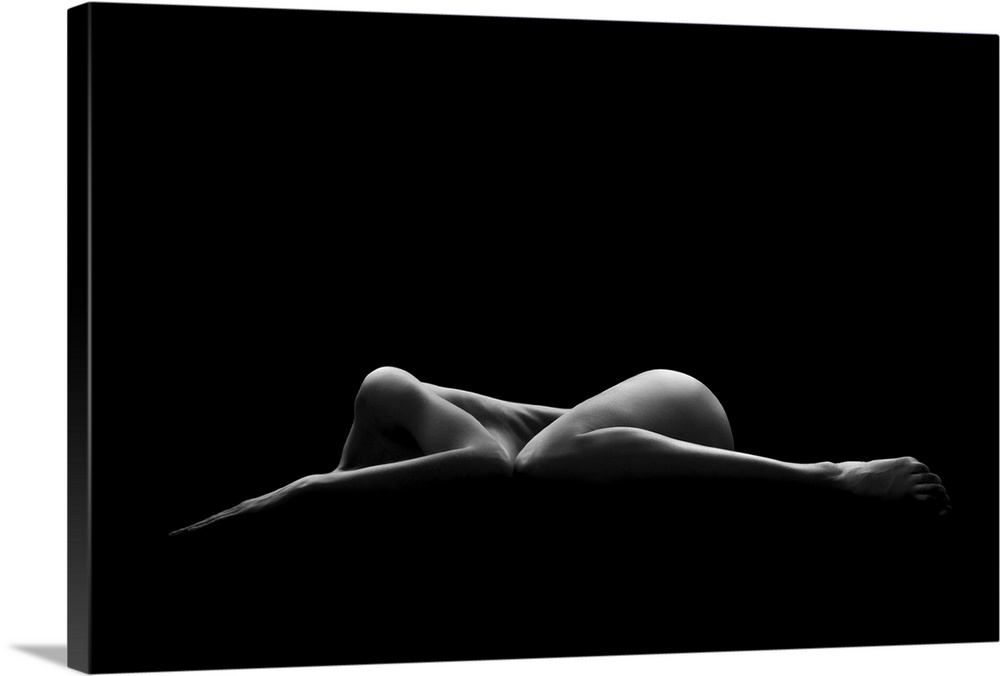 A nude female form seen partially illuminated in a dark environment.