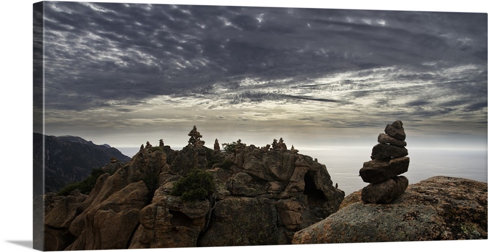 Rocky cliff landscape under a blanket of smooth looking clouds.