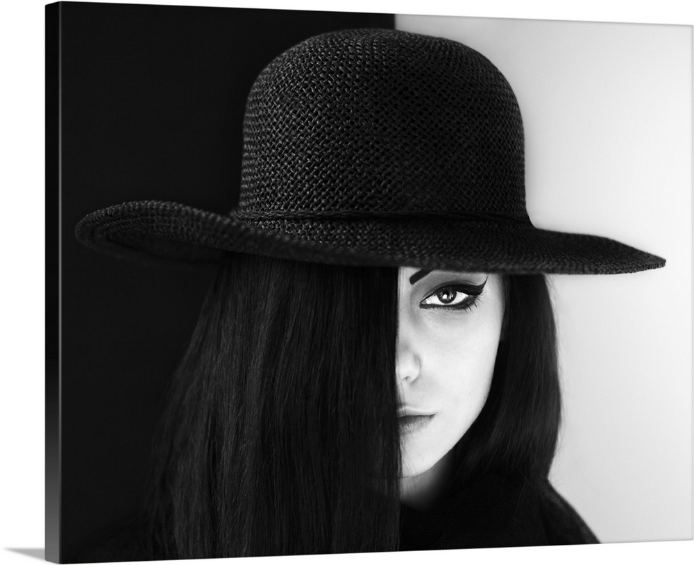 Portrait of a woman with face half obscured, wearing a large hat.