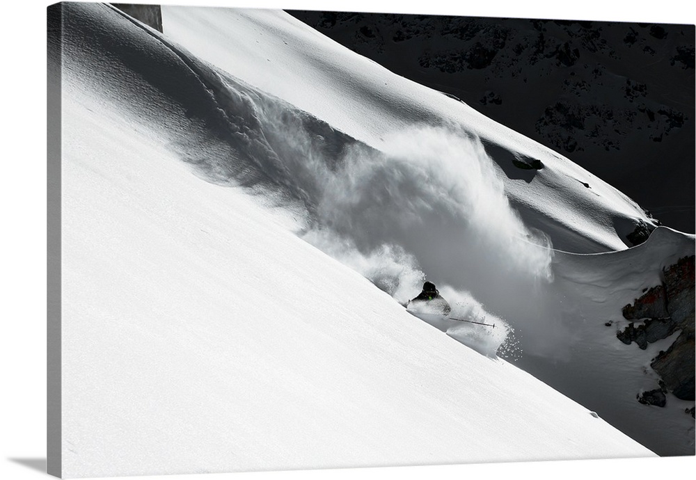A skier creating a trail of snowy powder as he skis down the mountainside in Verbier, Switzerland.