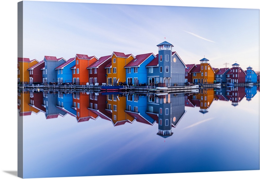 Blue and orange buildings mirrored in the water of the harbor at Groningen, Netherlands.