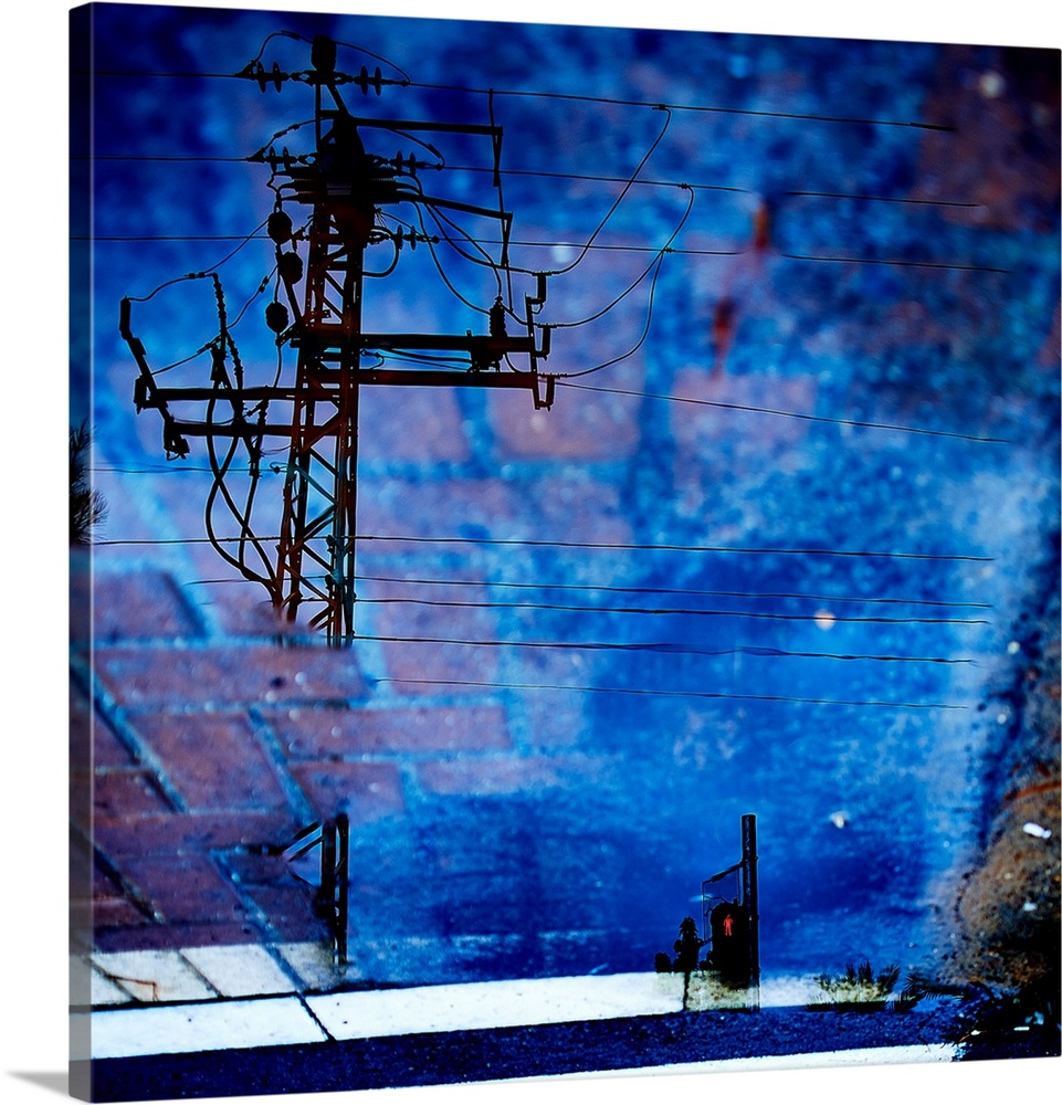 A reflection of power lines in a vibrant blue puddle of water.