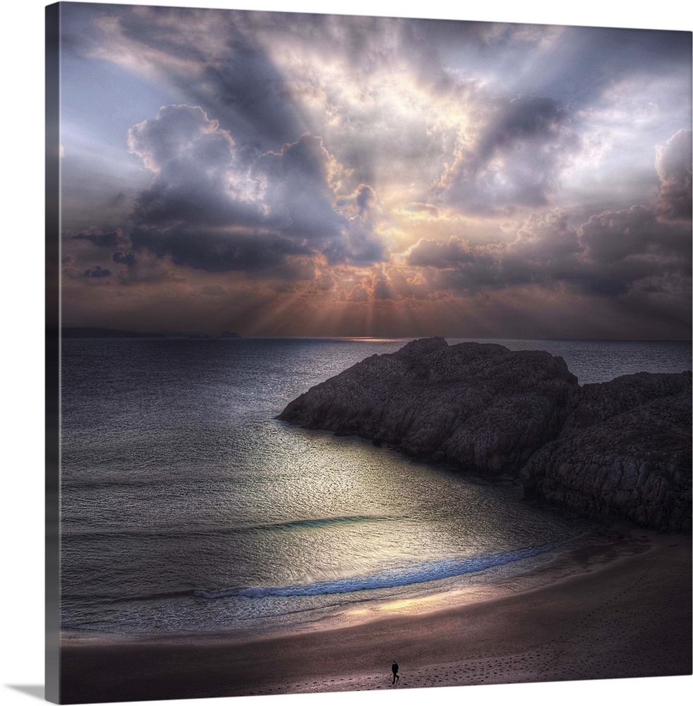 Seascape with a figure walking along the  beach and rock formations in the ocean, during sunset with a cloudy sky.