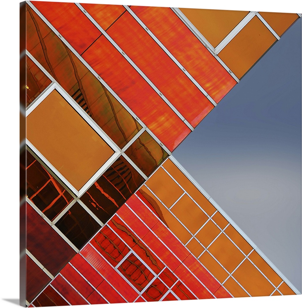 Orange glass panels on the facade of a building, with complex lines, creating an abstract image.