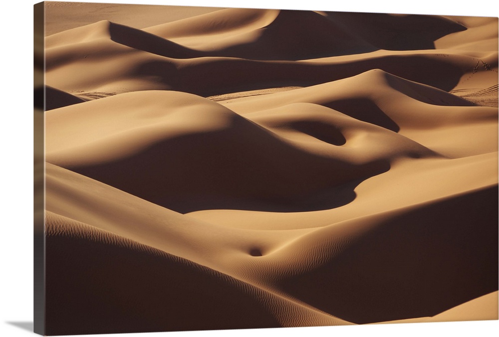 The rolling sand dunes of the Sahara desert appear smooth.