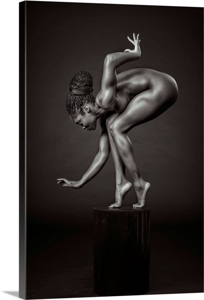 Black and white fine art photograph of an African American woman balancing and posing on a pedestal, resembling a sculpture.