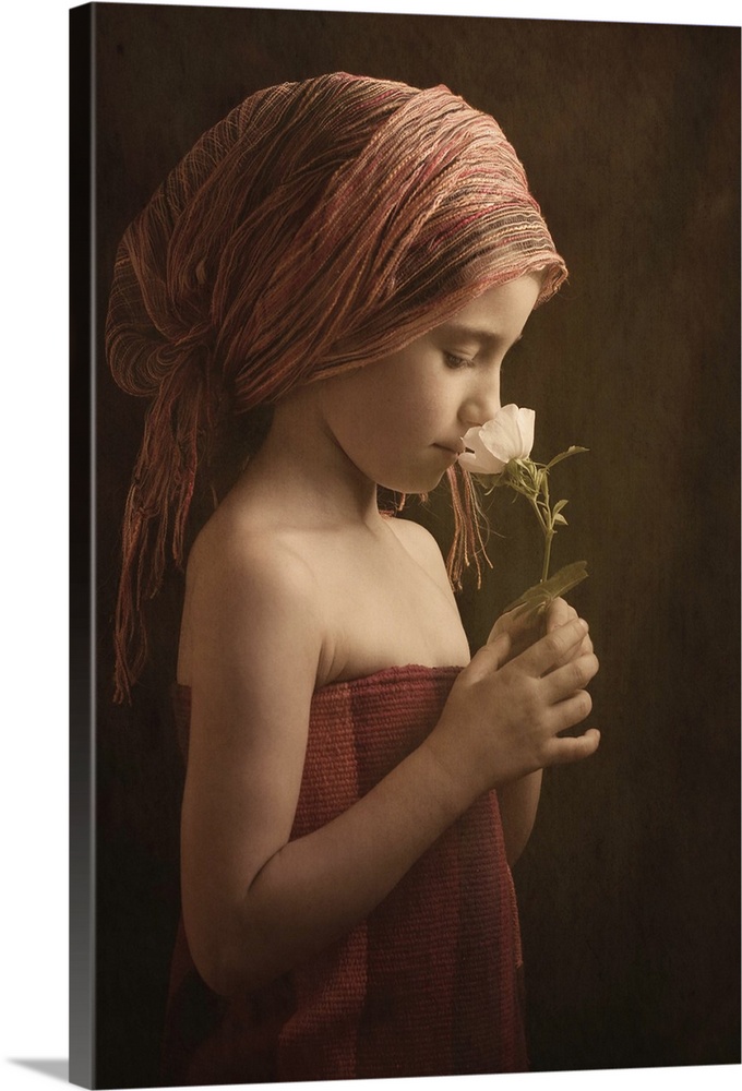 Portrait of a girl wearing robes smelling a flower.