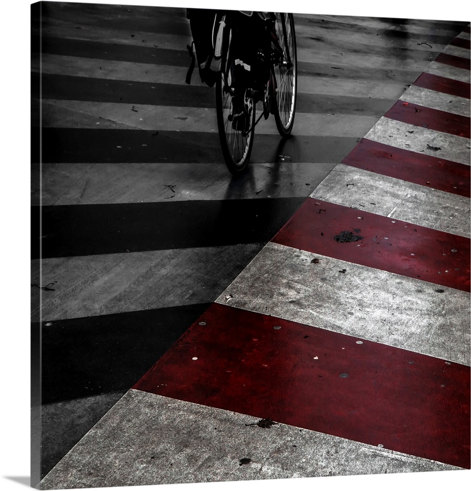 A bicycle on the street with red and white stripes painted on the road.