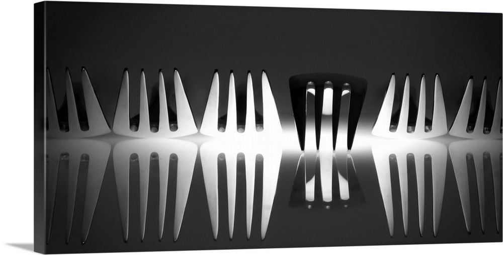 Abstract image of a row of forks with light reflecting from below with one turned upside down.