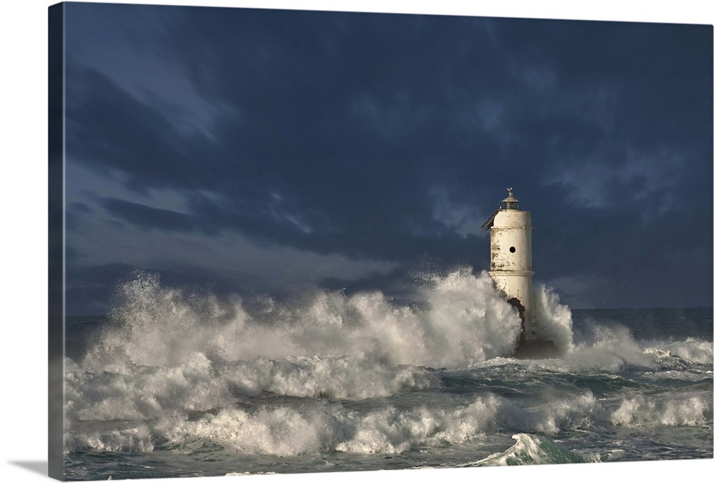 Ocean waves crashing on a lighthouse in Calasetta, Province of Carbonia-Iglesias, Italy.