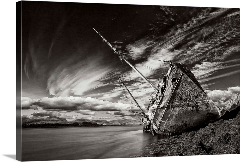 A black and white photograph of a derelict ship washed up on the shores of Iceland.