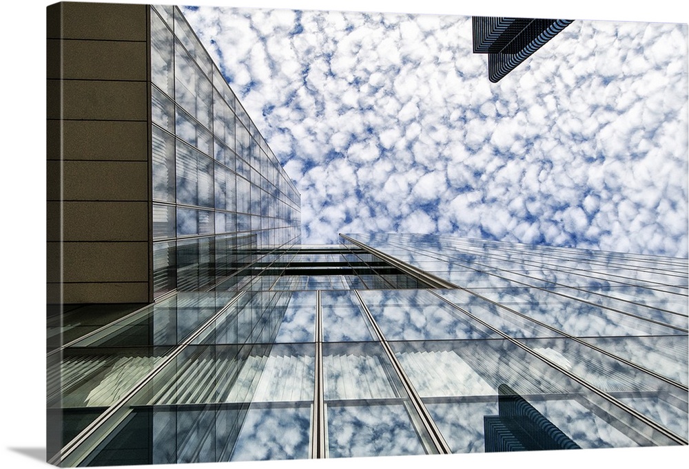 The glass facade of a skyscraper in Brussels reflecting the clouds in the sky.