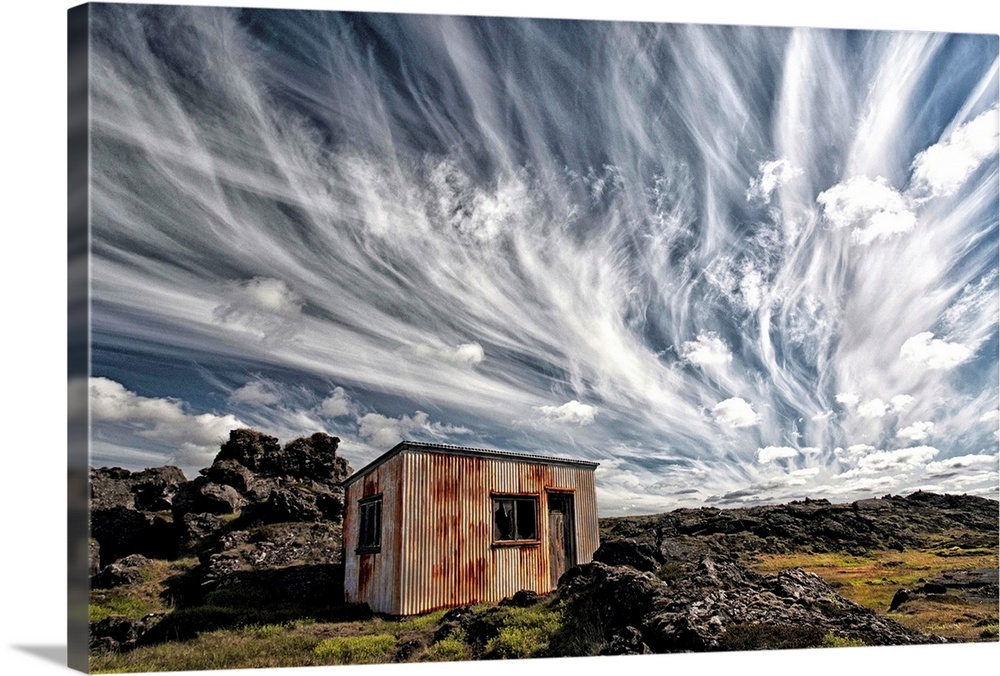 A dramatic skyscape over a derelict shack in the Icelandic countryside.