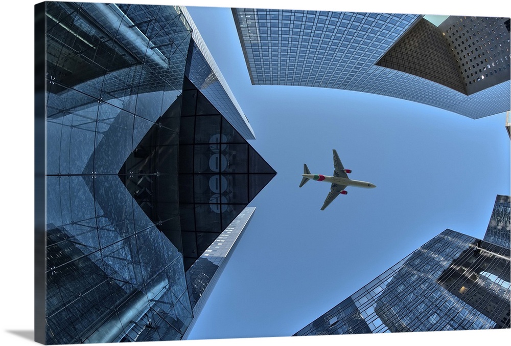 An airplane in the sky, framed by the skyscrapers of La Defense, Paris, France.