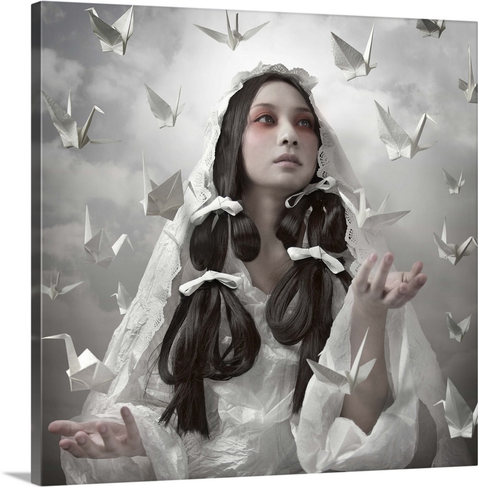 Conceptual image of a beautiful woman in a white robe with paper cranes floating around her.