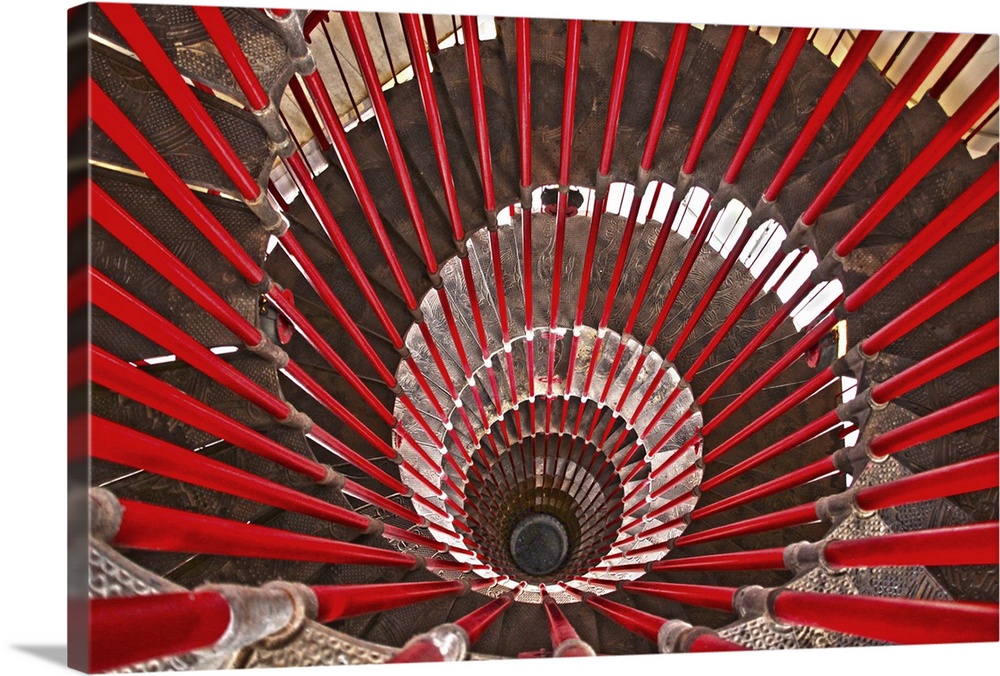 A massive spiral staircase lined with bright red banister rails.