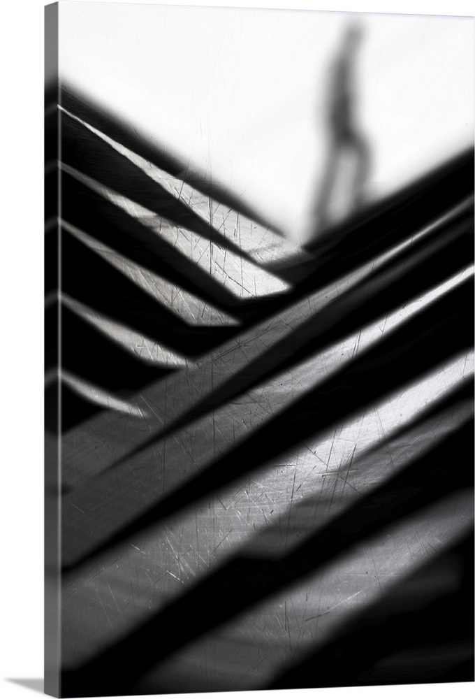Abstract black and white image of criss-crossing metal, with a blurry figure in the distance.