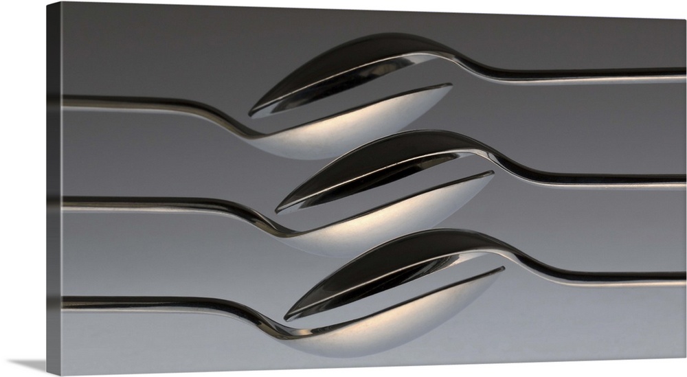 Six spoons arranged to form a wave-like pattern.