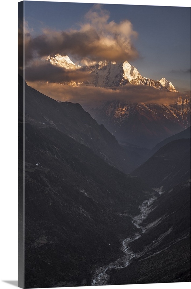 A dynamic photograph of a mountain range above a deep valley.