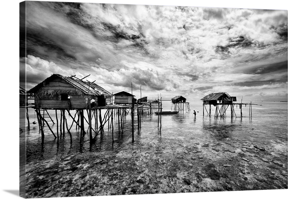 Black and white image of a group of houses on stilts in the ocean, Sabah, Malaysia.