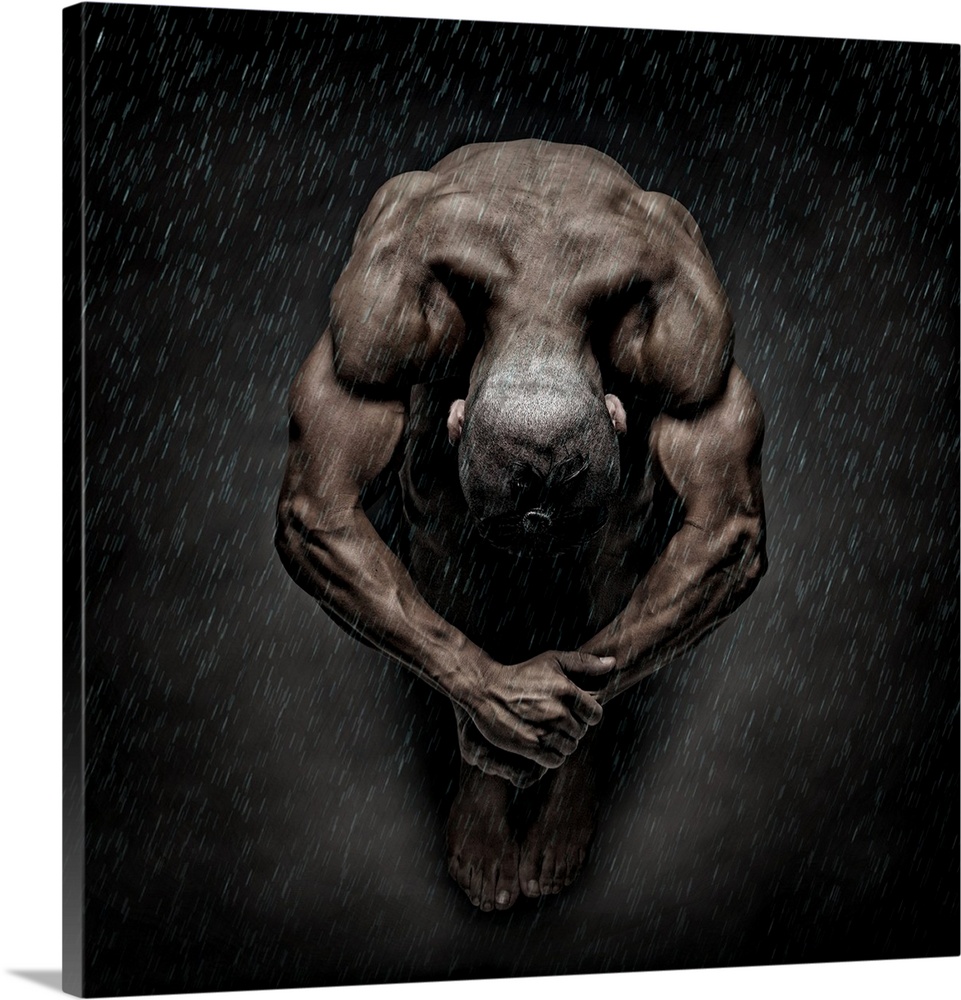 Nude fine art photograph of a muscular man sitting in a ball while it rains.