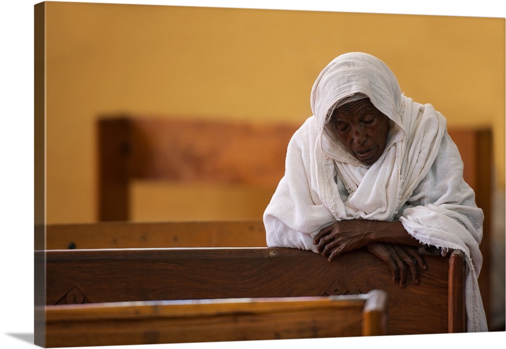 A woman in a white scarf praying at Maryam Tsyon cathedral in Axum, Ethiopia.