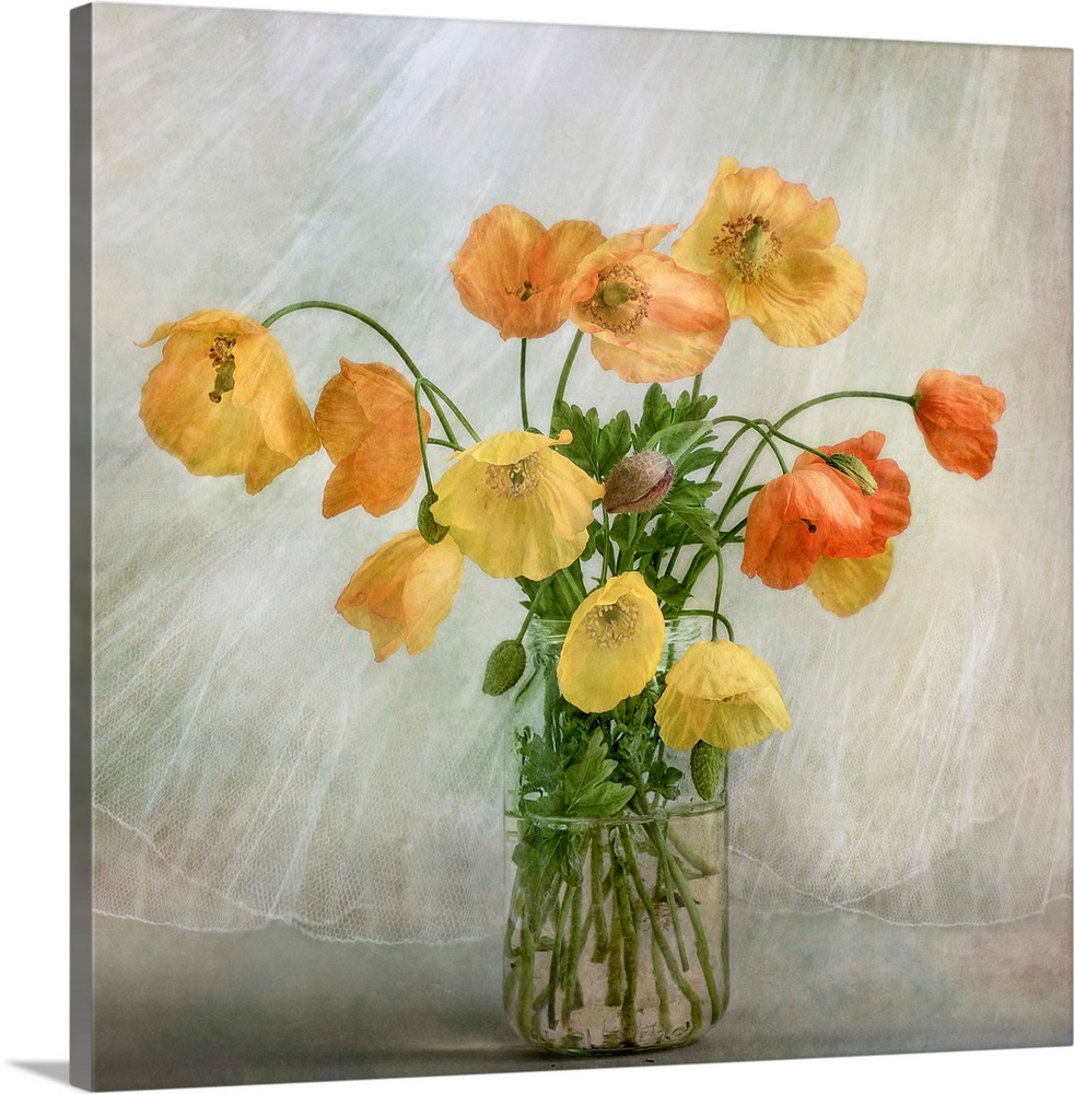 A glass jar full of yellow and orange poppies.