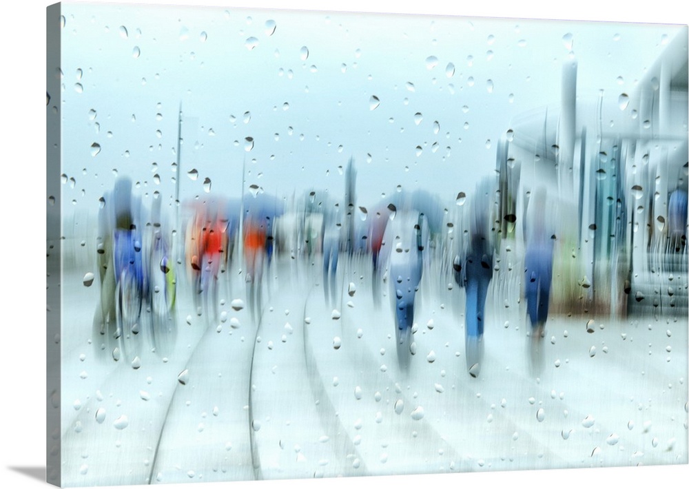 People walking in the street on a rainy day, seen behind blurry glass with raindrops.