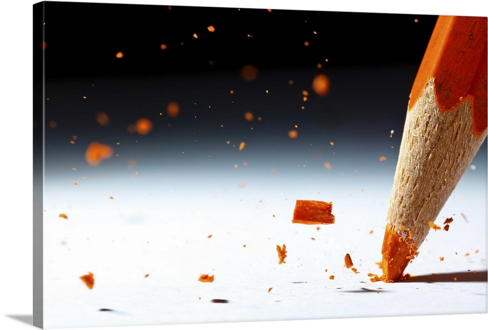 Close up image of the lead of an orange colored pencil shattering.