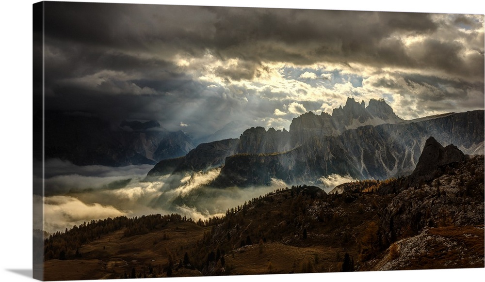 Ray of sunlight shining through the clouds onto the peaks of the Dolomites.